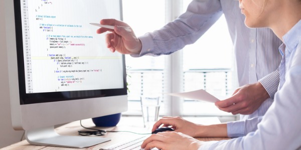 Two JavaScript (JS) programmers looking at the computer together.
