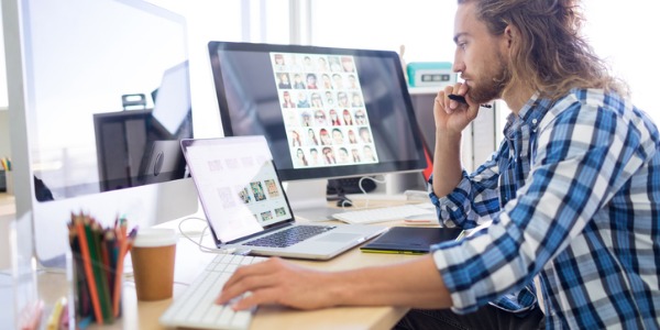 A graphic designer working on a project on his computer.