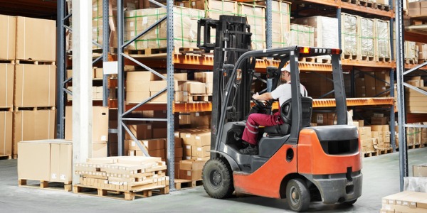 A forklift operator operating a forklift in a warehouse.