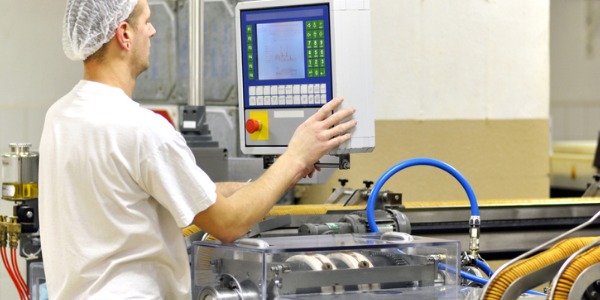 A food batchmaker observing a temperature gauge to ensure that the temperature is within the specified limits.