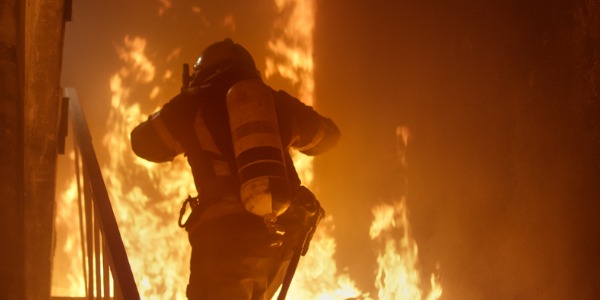 A firefighter fighting a raging fire.