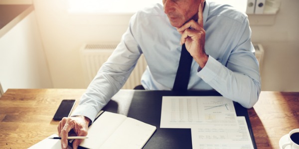 A financial manager going over some reports at his desk.