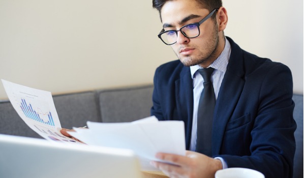 An economist at his desk analyzing economic data.