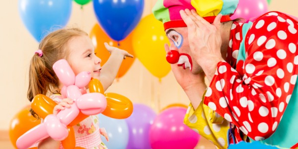 A clown making a little girl laugh.