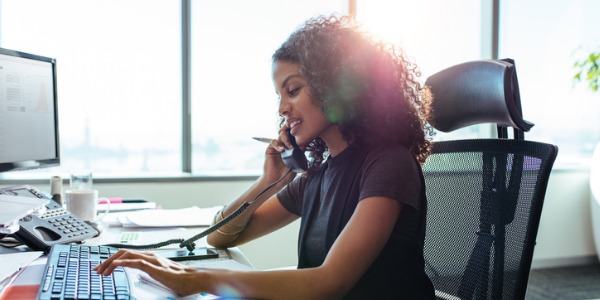 A childcare program administrator taking care of the scheduling on the computers.