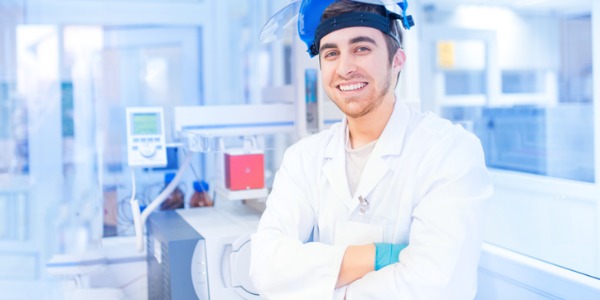 A chemical technician smiling in a laboratory.