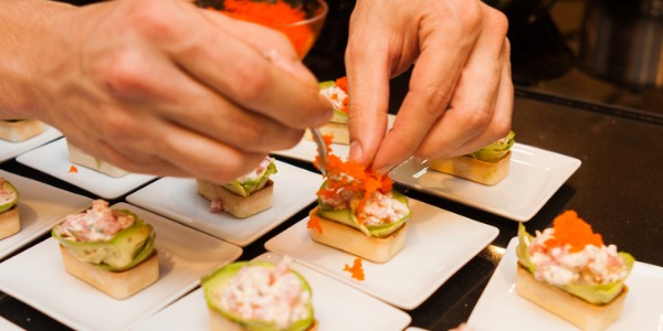 A caterer arranging food presentation for a client.