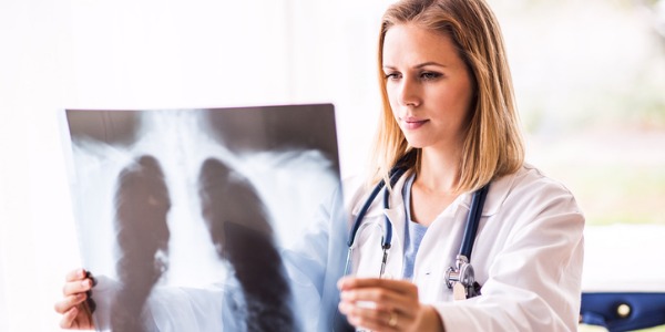 een cardiothoracale chirurg die een röntgenfoto van de longen van een patiënt bekijkt.'s lungs.