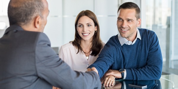 A bank manager meeting with a couple to discuss their banking needs.