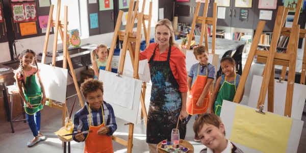 An art teacher in the art room with her students.