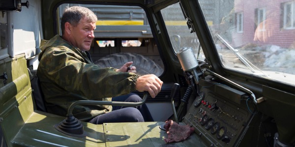 An armored assault vehicle crew member driving an assault vehicle.