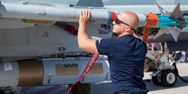 An air weapons specialists inspecting an aerial weapon on an aircraft.