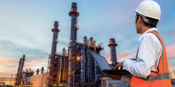A biofuel manufacturing research engineer outside a processing plant.