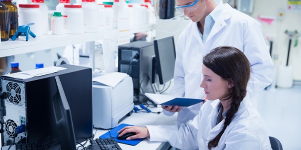 An agricultural and food science technician working in the lab with an assistant.