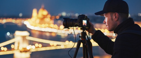 Landscape photographer taking a picture of city lights.