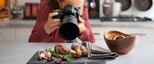 Food photographer setting camera up to take photos of a plate of food.