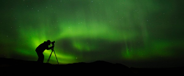 A professional photographer taking a picture of the northern lights.