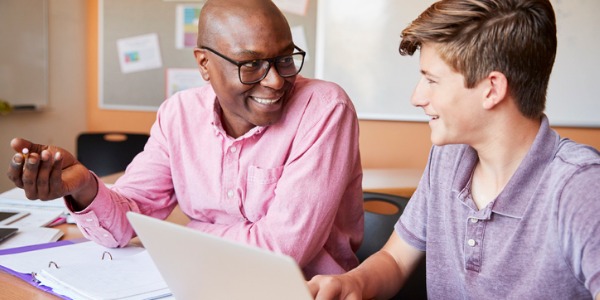 A high school teacher helping a student.