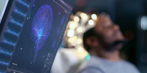 Man wearing a brainwave scanning headset, sitting in a chair in the brain study research laboratory.