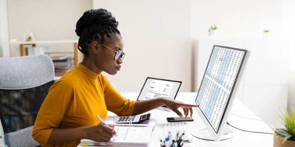 A healthcare administrator sitting at her desk, planning staff schedules.