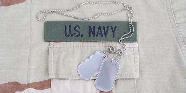 US navy officer dog tags with a navy uniform background.