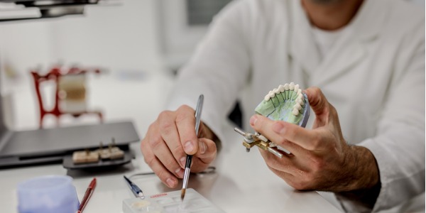 A dental laboratory technician working on ceramic dental implants.