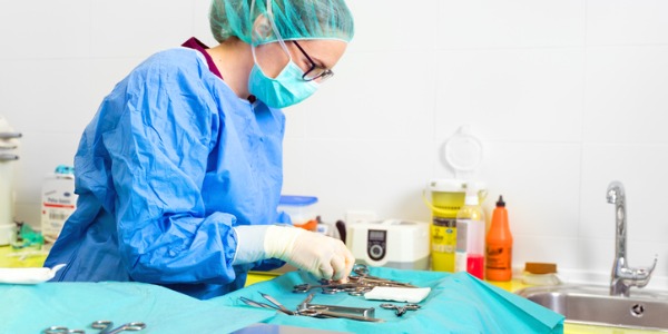 A surgical technologist setting up surgical instruments.