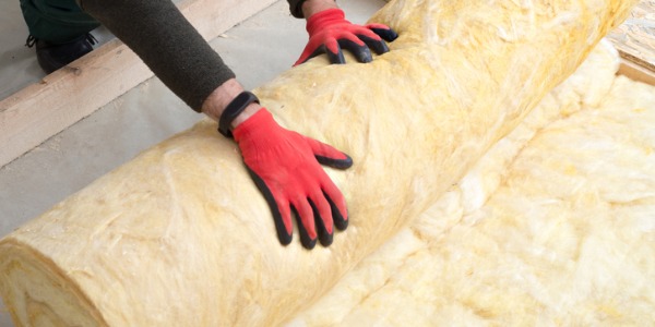 A weatherization technicians installing insulation.