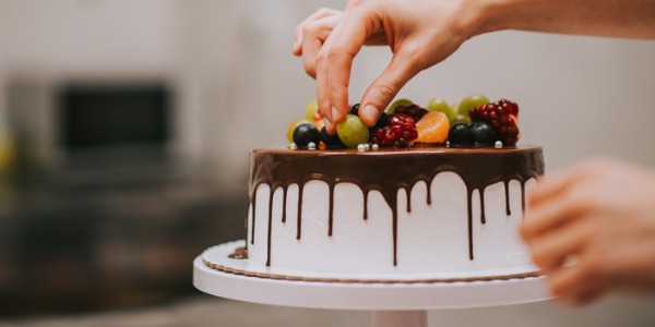 A cake designer decorating a cake.