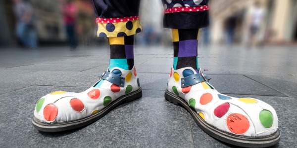Clown's feet on a sidewalk.