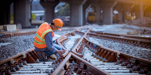 A railroad inspector inspecting a railroad track.
