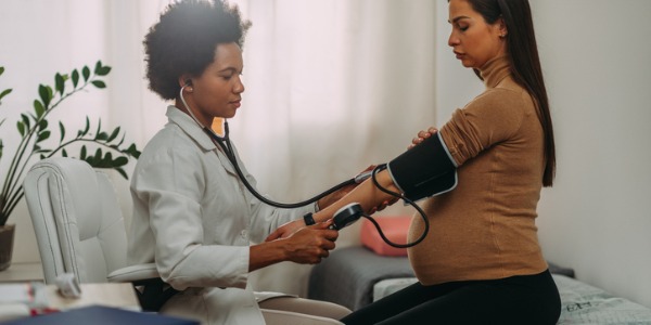 An obstetrician taking a pregnant woman's blood pressure.