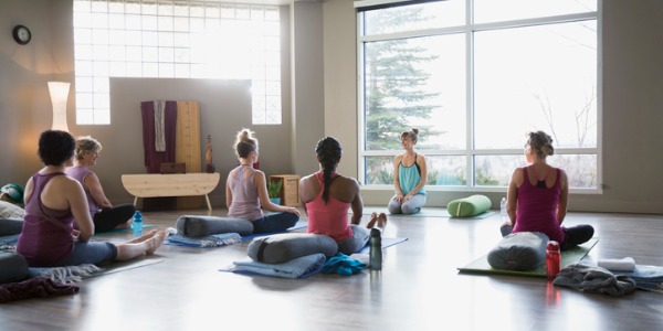 A yoga instructor teaching a restorative yoga class.