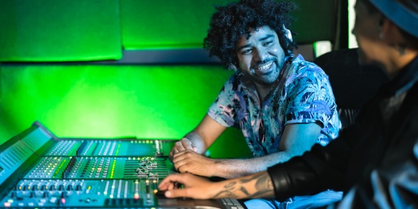 Two mixing engineers sitting in front of a mix panel.