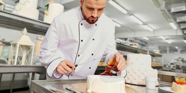 A special occasion cake designer decorating a cake.