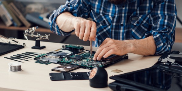A computer repair technician repairing a computer.