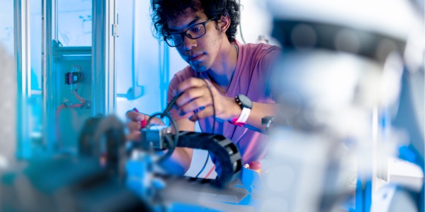 research on robotic engineering A robotics engineer working on a robotic arm.