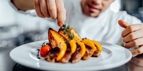 A culinary chef preparing a plate of food.