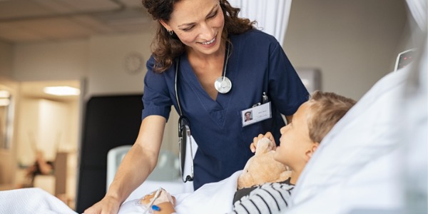 A nurse with a young patient in a hospital room.