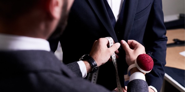 A tailor measuring a customer for a new suit.