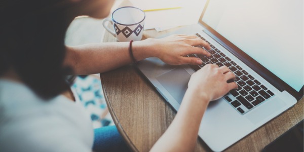 A content writer typing on a computer.