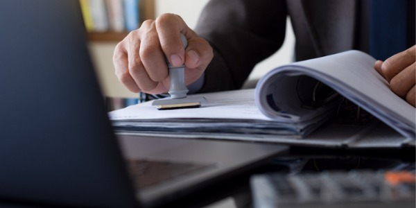 A customs broker stamping paperwork.