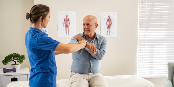 A geriatric chiropractor with an older patient.