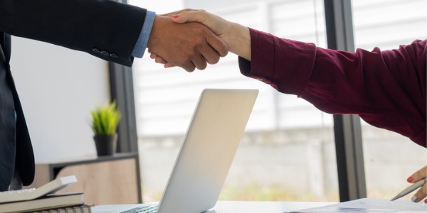 An account manager shaking hands with a client.