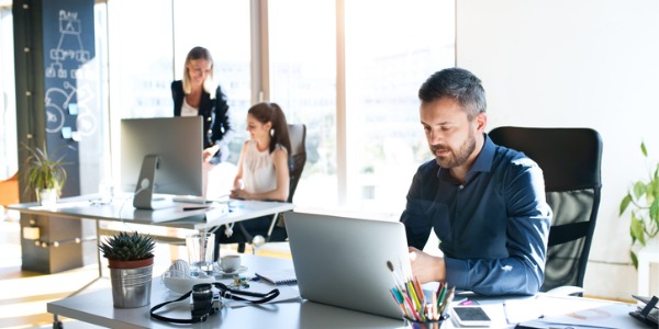 A content manager working on his computer, writing and editing content.