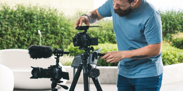 An audio visual technician setting up a camera and audio equipment.