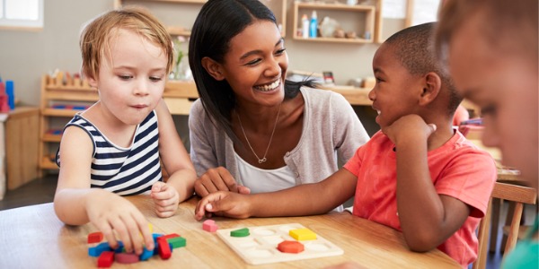 A childcare worker playing with children.