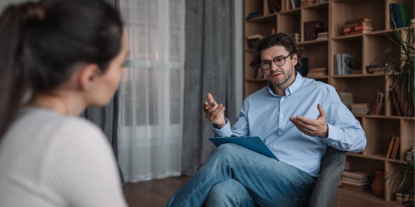 A health psychologist conducting a clinical interview and behavioral assessment of a patient.