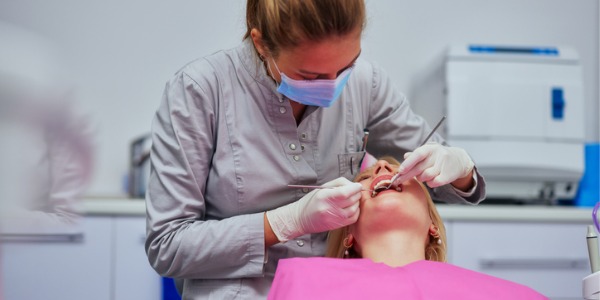 A dental hygienist cleaning a patient