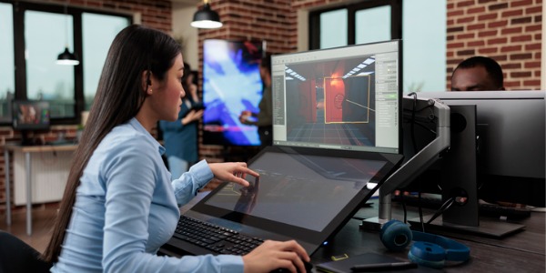 A games artist sitting in front of a computer, creating visual elements for a video game.